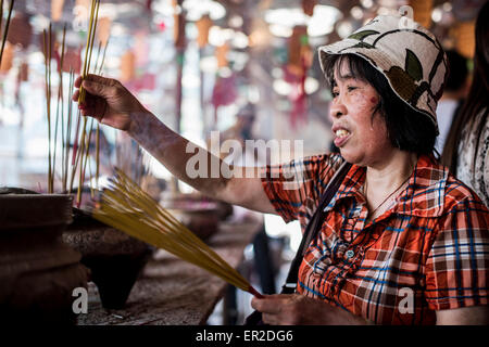 Cheung Chau isola. 25 Maggio, 2015. Un adoratore luci incenso davanti al piu Sik Parade presso Bun Festival in Cheung Chau isola il 25 maggio 2015 a Hong Kong. Uno di Hong Kong è più colorato celebrazione culturale eventi, Cheung Chau Bun Festival, sarà di scena il 25 maggio 2015 fino al 26 maggio 2015 a mezzanotte. Ogni anno migliaia e migliaia di persone scendono sulla piccola isola per i piu Sik Parade, Lucky Bun e il BUN Concorso di scrambling, l antica usanza durante il festival. La tradizione è stata tramandata per generazioni. Credito: Xaume Olleros/Alamy Live News Foto Stock