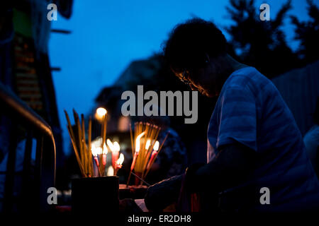 Cheung Chau isola. 25 Maggio, 2015. Un adoratore luci bastoncini di incenso durante il Bun Festival in Cheung Chau isola il 25 maggio 2015 a Hong Kong. Uno di Hong Kong è più colorato celebrazione culturale eventi, Cheung Chau Bun Festival, sarà di scena il 25 maggio 2015 fino al 26 maggio 2015 a mezzanotte. Ogni anno migliaia e migliaia di persone scendono sulla piccola isola per i piu Sik Parade, Lucky Bun e il BUN Concorso di scrambling, l antica usanza durante il festival. La tradizione è stata tramandata per generazioni. Credito: Xaume Olleros/Alamy Live News Foto Stock