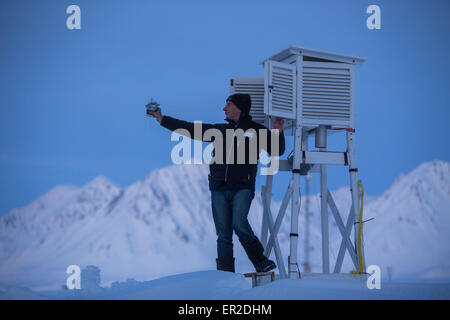 Il tecnico Juergen Graeser dell'Osservatorio atmosferica di AWIPEV stazione di ricerca metorological prove tecniche di misurazione utilizzate per la radio sondaggio in Ny-Alesund sull isola Spitsbergen, Norvegia, 09 aprile 2015. Il francese e il tedesco gli scienziati stanno lavorando in Artico stazione di ricerca AWIPEV sui terreni della ex sito minerario sull'arcipelago delle Svalbard. Foto: Jens Buettner/dpa Foto Stock