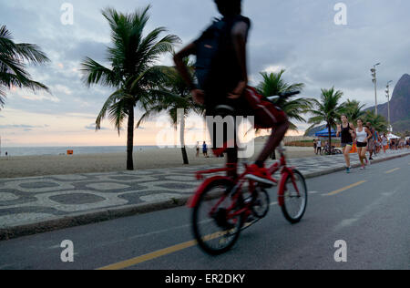 Ciclista e guide sulla spiaggia di Ipanema, Rio Foto Stock