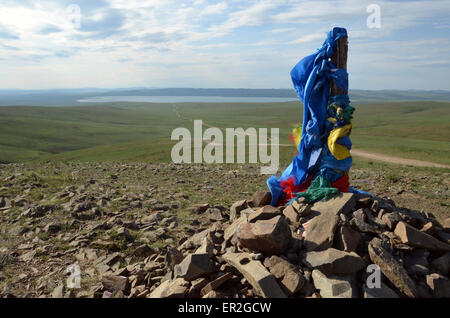 Un tumulo con bandiere di preghiera in un passaggio che si affaccia sul lago Ugiin da un passaggio in provincia Arhangay, Mongolia Foto Stock