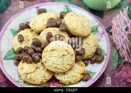 I cookie di integrale e le sfere di cioccolato in un colorato tavolino con fiori Foto Stock