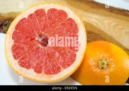 Fresco affettato pompelmo su una tavola di legno Foto Stock