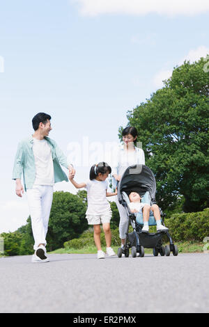 Felice famiglia giapponese in un parco della città Foto Stock