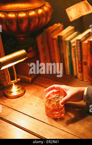 Uomo giapponese con un bicchiere di whiskey in un bar alla moda Foto Stock