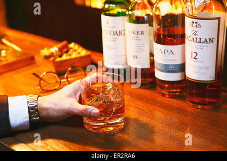 Uomo giapponese con un bicchiere di whiskey in un bar alla moda Foto Stock