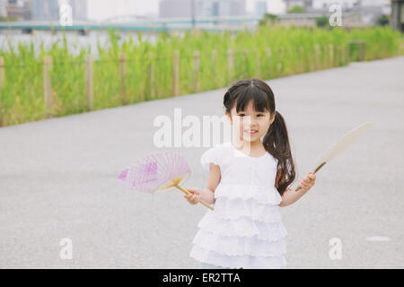 Ragazza giovane con la ventola della carta Foto Stock