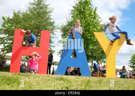 Festival di fieno, POWYS, GALLES - 26 maggio 2015 Termine di mezza giornata per la famiglia per godersi una possibilità di sedersi leggere e rilassarsi sul prato presso il Festival di fieno. Il festival letterario ha molte sessioni e gli eventi per gli autori di libri per bambini per giovani lettori a partecipare. Foto Stock