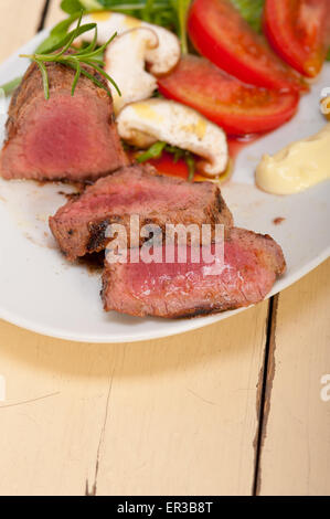 Filetto di manzo alla griglia di mignon con verdura fresca sul lato ,funghi pomodoro e insalata di rucola Foto Stock