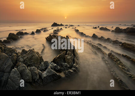 Barrika spiaggia al tramonto con golden calda luce Foto Stock