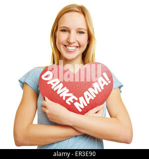 Felice ragazza con un cuore rosso con testo tedesco 'Danke Mama!" (grazie mama!) per la festa della mamma Foto Stock