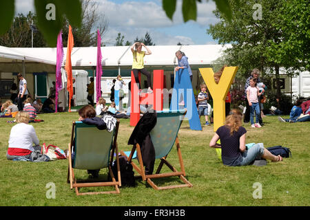 Festival di fieno, POWYS, GALLES - Maggio 2015 - festival di prati di fornire un ottimo posto per sedersi e rilassarsi nel tempo soleggiato. Half Term divertente per i bambini presso il Festival di fieno in cui giocare Intorno prati e sul gigante segno di fieno. Foto Stock