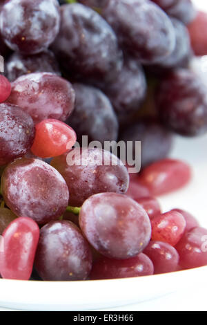 Uve di porpora viola vs Jelly Beans - snack decisione tra alimenti sani o cibo spazzatura Foto Stock