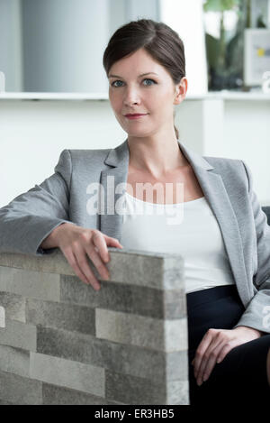 Donna seduta in area di attesa Foto Stock