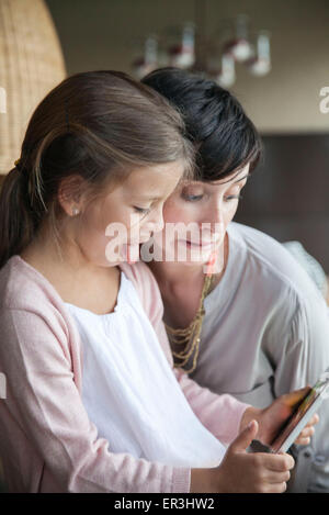 Madre e figlia giovane con tavoletta digitale e facendo facce buffe Foto Stock