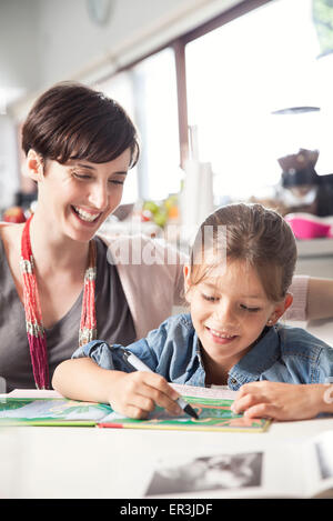 Insegnamento madre giovane figlia di leggere Foto Stock