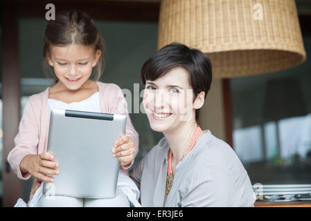 Madre e figlia con tavoletta digitale insieme Foto Stock