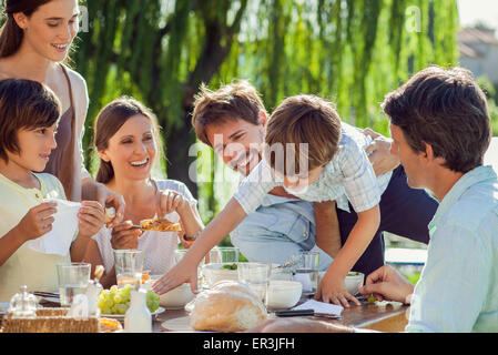 Famiglia gustando la prima colazione insieme all'aperto Foto Stock