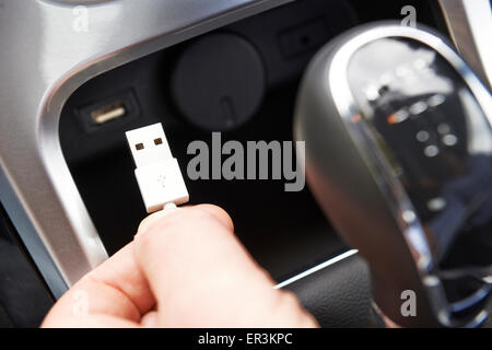 Stretta di mano che trattiene il connettore USB in auto Foto Stock