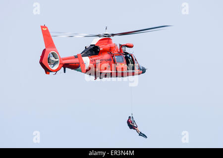 Un HH-65 Delfino di Stati Uniti Coast Guard si abbassa di un nuotatore di salvataggio mentre passando sopra il lago Michigan off Chicago, Illinois. Foto Stock