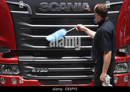 Hannover, Germania. 05 Maggio, 2015. Un uomo che pulisce la parte anteriore di un autocarro Scania durante l'assemblea degli azionisti il tedesco di casa automobilistica Volkswagen AG di Hannover, Germania, 05 maggio 2015. Foto: Ole Spata/dpa/Alamy Live News Foto Stock