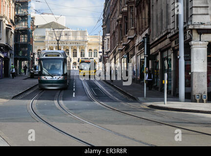 Un Nottingham NCT tram accanto a un parco giallo e autobus, su Market Street, Nottingham, Inghilterra. Foto Stock