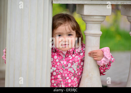 Due anno vecchia ragazza guarda fuori dal gazebo Foto Stock