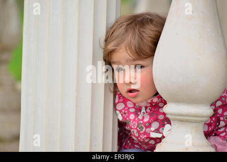Due anno vecchia ragazza guarda fuori dal gazebo Foto Stock