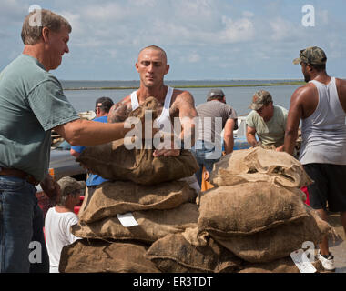 Eastpoint, Florida - Oystermen scaricare 60-pound sacchetti di raccolti di fresco ostriche al barbiere di frutti di mare. Foto Stock