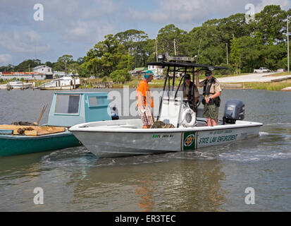 Eastpoint, Florida - Ufficiali della Florida pesci e fauna selvatica Commissione parla di un oysterman su Apalachicola Bay. Foto Stock
