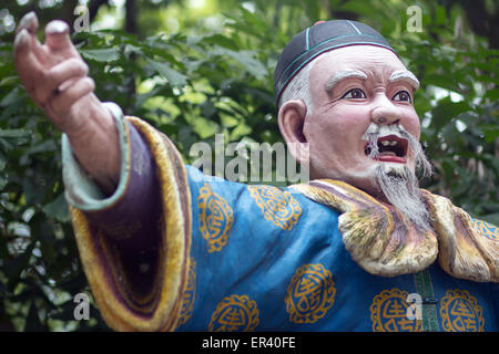 Un vecchio uomo in un tradizionale costume cinese mostra la direzione a mano Foto Stock
