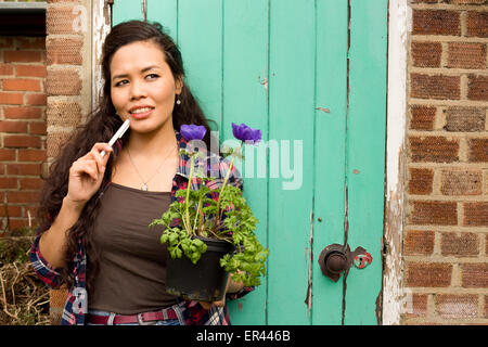 Giovane donna pensando in giardino Foto Stock