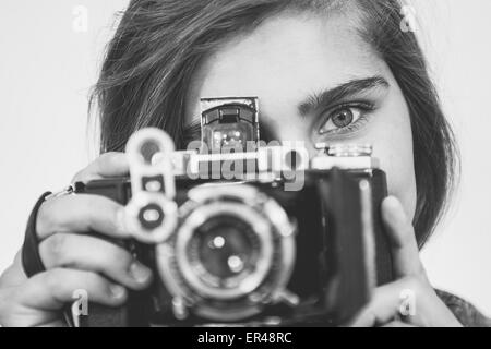 Adolescente ragazza con una vecchia telecamera di piegatura verticale. Foto Stock