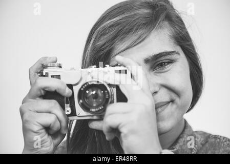 Adolescente ragazza con una vecchia telecamera di piegatura verticale. Foto Stock