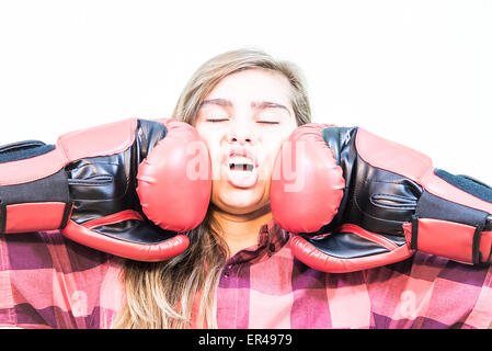 Ragazza punzonati con due guantoni da pugilato. Sfondo bianco. Foto Stock