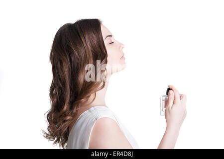 Giovane donna spruzzando il profumo Foto Stock