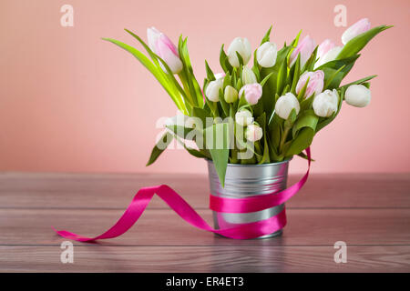 I tulipani in un contenitore su un tavolo di legno Foto Stock