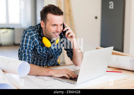 Sorridente operaio edile parlando al telefono cellulare. Pilzno, Polonia Foto Stock