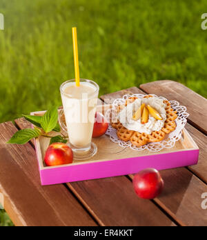 Waffle e frullato sul tavolo di legno nel giardino. Debica, Polonia Foto Stock
