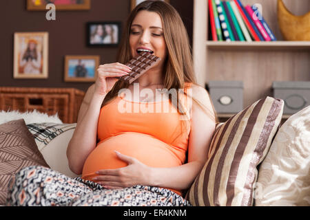 Donna incinta godendo di mangiare il cioccolato. Debica, Polonia Foto Stock
