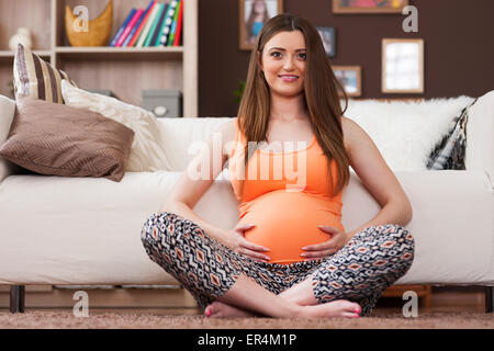 Ritratto di bella donna incinta a casa. Debica, Polonia Foto Stock