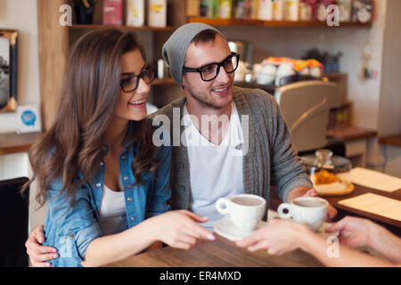 Moda giovane la ricezione di tazza di caffè dalla cameriera. Cracovia in Polonia Foto Stock