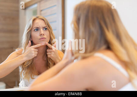 Arrabbiato donna spremitura brufolo dalla faccia. Debica, Polonia Foto Stock