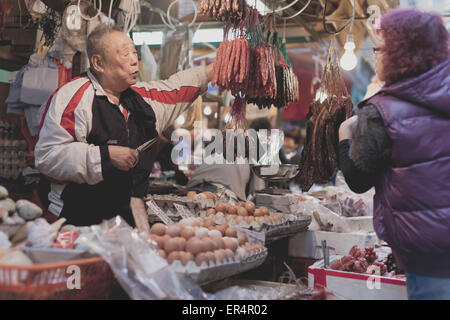 HONG KONG - Gennaio 4: a Hong Kong vecchio uomo sta lavorando al suo stallo in Hong Kong il 4 gennaio 2014. Foto Stock