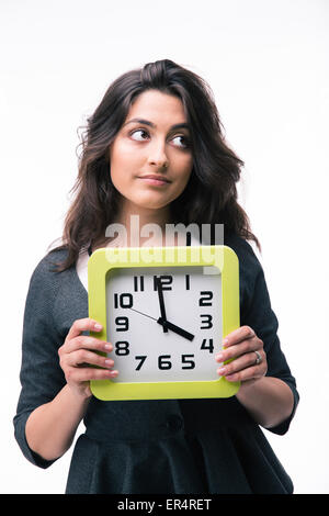 Malinconici imprenditrice azienda orologio isolato su uno sfondo bianco e guardando lontano Foto Stock