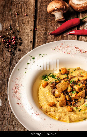 Porridge di mais con la zucca in bianco sullo sfondo di legno Foto Stock