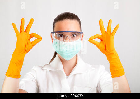 Chirurgo femmina indossando guanti di lattice, mostrando segno OK Foto Stock