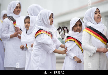 Hanau, Germania. 27 Maggio, 2015. Le giovani ragazze che indossano il tedesco infissi e tenendo le bandiere raffiguranti la mezzaluna islamica attendere l'arrivo degli ospiti d'onore durante l'apertura del nuovo esca-ul-Wahid moschea di La musulmana Ahmadiyya Jamad denominazione in Hanau, Germania, 27 maggio 2015. La moschea ha due 12-metri alti minareti e offre spazio per un massimo di 500 persone. Foto: BORIS ROESSLER/dpa/Alamy Live News Foto Stock