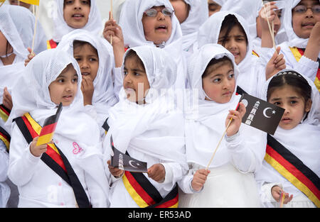 Hanau, Germania. 27 Maggio, 2015. Le giovani ragazze che indossano il tedesco infissi e tenendo le bandiere raffiguranti la mezzaluna islamica attendere l'arrivo degli ospiti d'onore durante l'apertura del nuovo esca-ul-Wahid moschea di La musulmana Ahmadiyya Jamad denominazione in Hanau, Germania, 27 maggio 2015. La moschea ha due 12-metri alti minareti e offre spazio per un massimo di 500 persone. Foto: BORIS ROESSLER/dpa/Alamy Live News Foto Stock