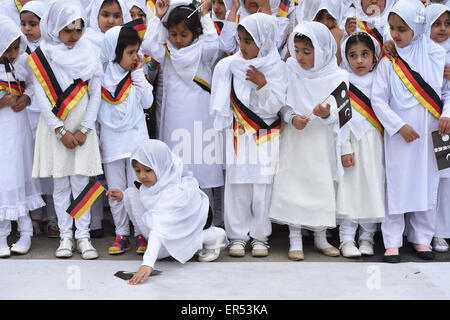 Hanau, Germania. 27 Maggio, 2015. Le giovani ragazze che indossano il tedesco infissi e tenendo le bandiere raffiguranti la mezzaluna islamica attendere l'arrivo degli ospiti d'onore durante l'apertura del nuovo esca-ul-Wahid moschea di La musulmana Ahmadiyya Jamad denominazione in Hanau, Germania, 27 maggio 2015. Una ragazza prende la sua bandiera. La moschea ha due 12-metri alti minareti e offre spazio per un massimo di 500 persone. Foto: BORIS ROESSLER/dpa/Alamy Live News Foto Stock